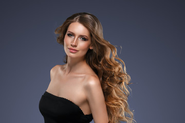 Naklejka premium Beautiful hair long curly hairstyle woman with beauty makeup female model portrait