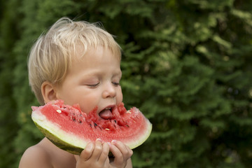 Cute baby boy Enjoy Eating The Watermelon on the green background