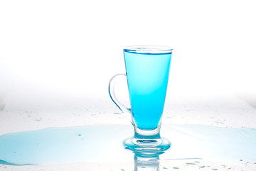 Water splashing into glass of water on white