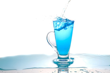 Water splashing into glass of water on white