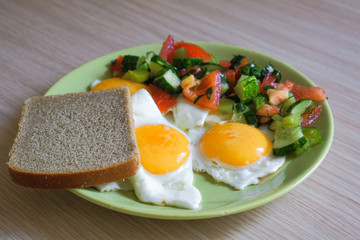 delicious fried chicken eggs with salad and bread on a plate