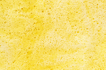 Yellow soap bubble foam. Abstract background.