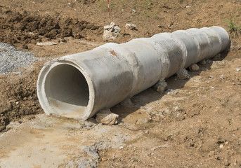 Concrete Drainage Pipe build on a Construction Site under the road. Concrete pipe stacked sewage water system aligned on site.