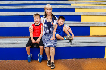 happy young grandmother hugging two grandchildren