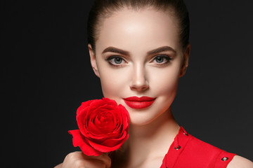 Fototapeta na wymiar Woman with rose flower. Beauty female portrait with beautiful rose flower and salon hairstyle over gray background