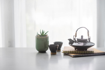 Fototapeta na wymiar Japanese ceramic tea pot and tea cup on table