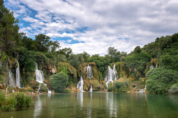 Picture beautiful waterfall in a green forest and a green lake