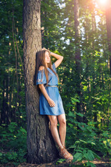 Nature, summer and people concept - Young woman posing in green forest