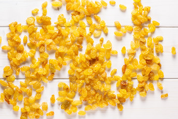 Lot of whole dry golden raisins sultana variety flatlay on grey wood