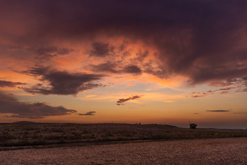 Fototapeta na wymiar Paesaggio di campagna al tramonto con cielo nuvoloso 
