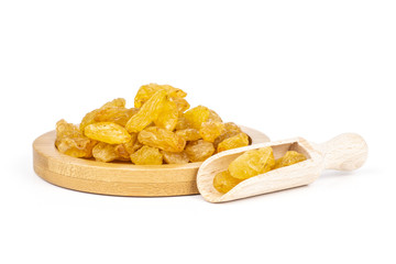 Lot of whole dry golden raisins sultana variety on bamboo plate isolated on white background