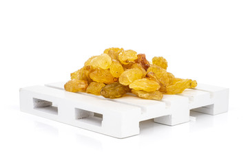 Lot of whole dry golden raisins sultana variety on white pallet isolated on white background