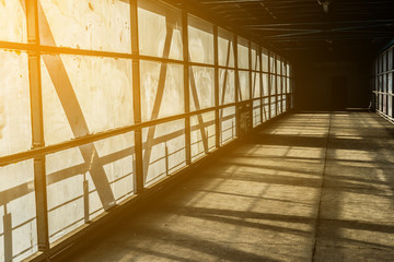 Modern overhead passage from steel and glass, perspective, long tunnel in sunset light