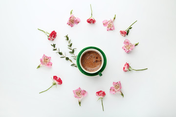 Flowers with cup of coffee on white background