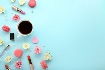 Rose flowers with cup of coffee and makeup cosmetics on blue background