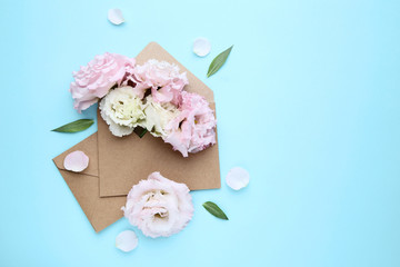 Eustoma flowers with envelopes on blue background