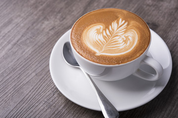 latte or Cappuccino with frothy foam, coffee cup top view on table in cafe.