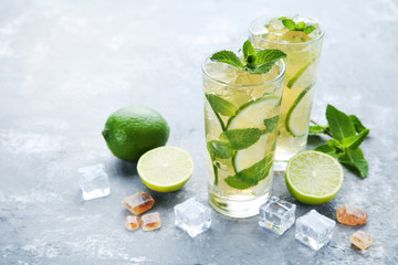 Mojito cocktail in glasses on grey wooden table