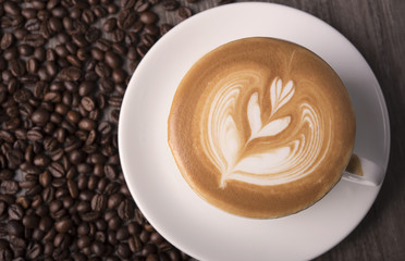 latte or Cappuccino with frothy foam, coffee cup top view on table in cafe.