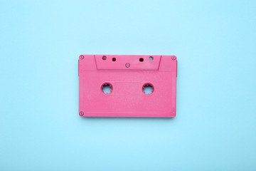 Pink cassette tape on blue background