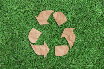 recycle symbol on green grass background top view. eco and save the earth concept.