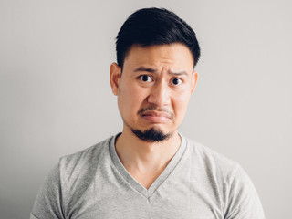 Obraz premium Headshot photo of Asian man with hate and disgusting face. on grey background.