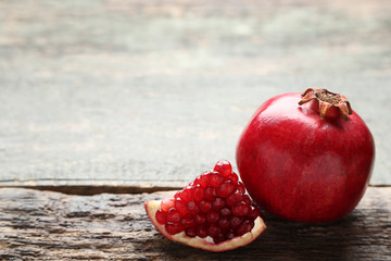 Ripe and juicy pomegranate on grey wooden table