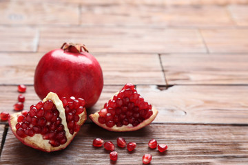 Ripe and juicy pomegranate on brown wooden table