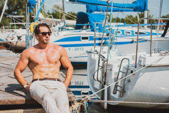 Sexy man on sailboat, relaxation in luxury sea cruise, summertime leisure time on water transport, freedom and enjoyment concept 