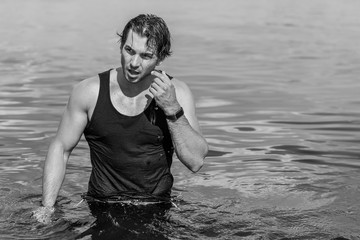 Handsome man in water, sexy guy showing muscular fit body. Concept os sport life of men. Muscular...