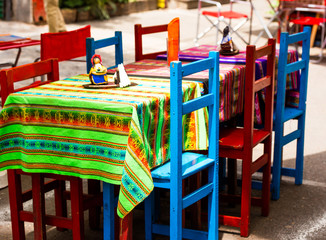 Fototapeta na wymiar View of multi-colored chairs in a cafe on a city street, Buenos Aires, Argentina. With selective focus.