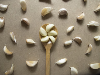 Garlic Cloves in a Wooden spoon on the MDF wooden plate board Texture Background