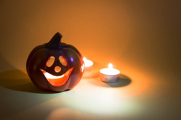 Halloween candle pumpkin on a yellow background.