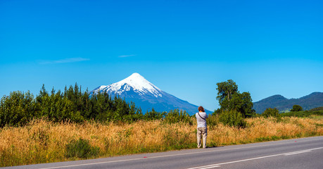 Photographer takes pictures of a mountain landscape in national park Vicente Perez Rosales, Chile. Copy space for text.