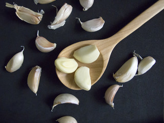 Garlic Cloves in a Wooden spoon on Black Background