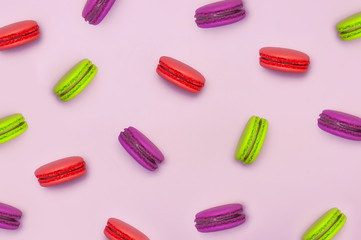 Pattern sweet macaroons on pink background top view flat lay. Delicious breakfast, beautiful dessert, colorful almond cookies, pastel colors.