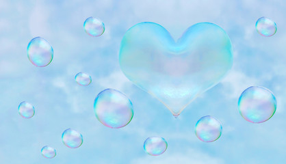 a heart-shaped soap bubble. blue sky background with clouds.