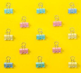 Fototapeta na wymiar colorful binder clips on yellow background