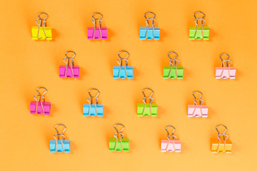 colorful binder clips on orange background