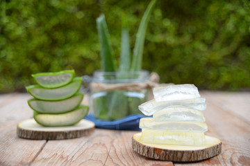 aloe vera gel on wooden spoon with aloe vera on wooden table
