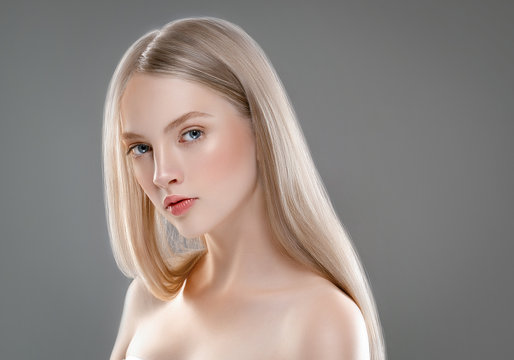 Beautiful Woman Face Portrait Beauty Skin Care Concept with long blonde hair  over gray background