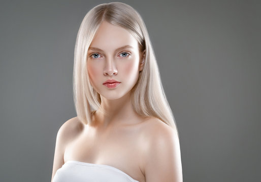 Fototapeta Beautiful Woman Face Portrait Beauty Skin Care Concept with long blonde hair  over gray background