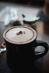 Hot chocolate in Black cup put on the table in cafe 