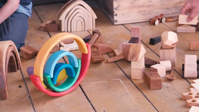Children are playing with wooden toys. Close-up hands.