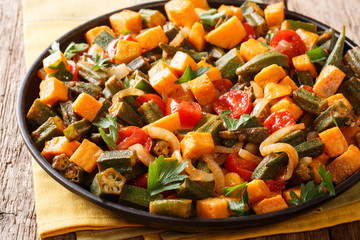 Organic health food cooked okra, sweet potatoes, tomatoes, onions and herbs closeup on a plate. horizontal