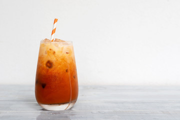 glass of Thai iced tea with milk on wooden table