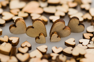 Fototapeta na wymiar Many small wooden hearts on a blurred background