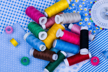 Multicolored threads, buttons on blue fabric
