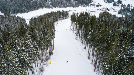 Skiers and snowboarders go down the slope in a ski resort Bukovel, Ukraine