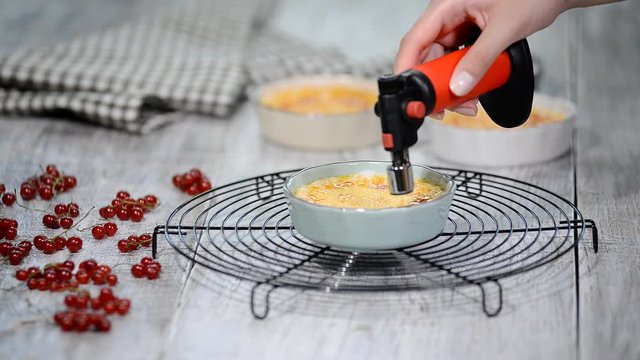 Burn portion of creme brulee dessert on kitchen. Delicious french dessert creme brulee